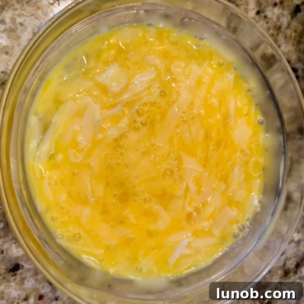 The egg and Parmigiano cheese mixture being poured and gently stirred into the Instant Pot Italian Wedding Soup, forming delicate ribbons.