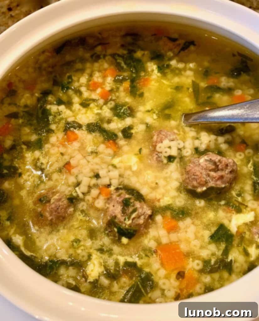 Serving Classic Italian Wedding Soup garnished with fresh Parmigiano cheese and a drizzle of olive oil, ready to enjoy.