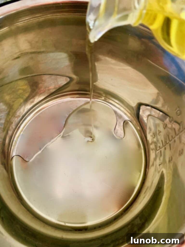 Instant Pot with golden-brown meatballs cooking in olive oil, a crucial step for flavorful Classic Italian Wedding Soup.
