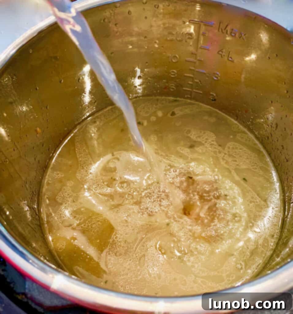 Chopped carrots and celery being added to the Instant Pot with broth and meatballs for a wholesome Italian Wedding Soup.
