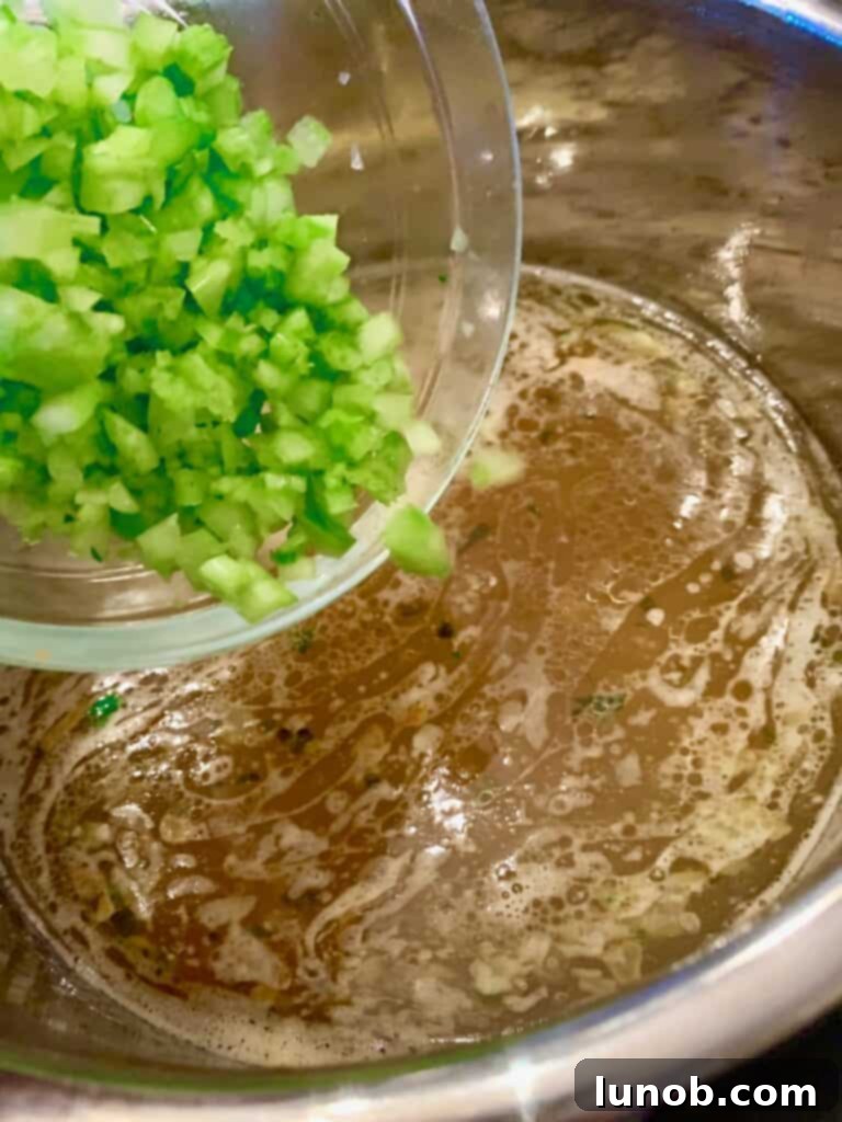 Adding fresh baby spinach to Instant Pot Italian Wedding Soup, a vibrant and healthy addition.