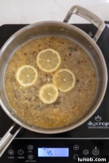 Velvety Lemon Sauce 6 White wine simmering with lemon slices and capers in a saucepan