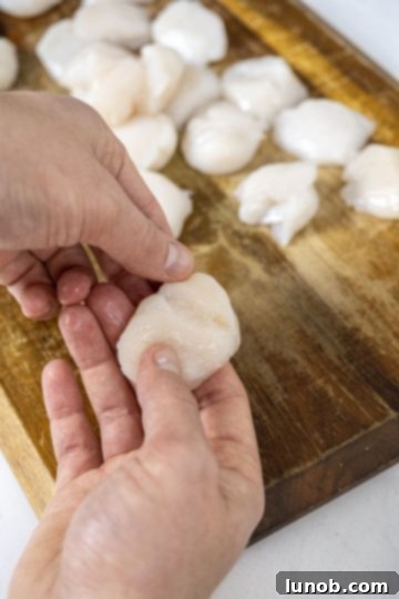 peeling muscle from scallop