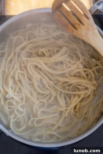 pasta finishing in the pan with clam sauce
