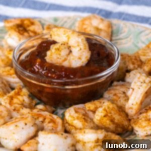 Shrimp Cocktail dipped in cocktail sauce, ready to be enjoyed