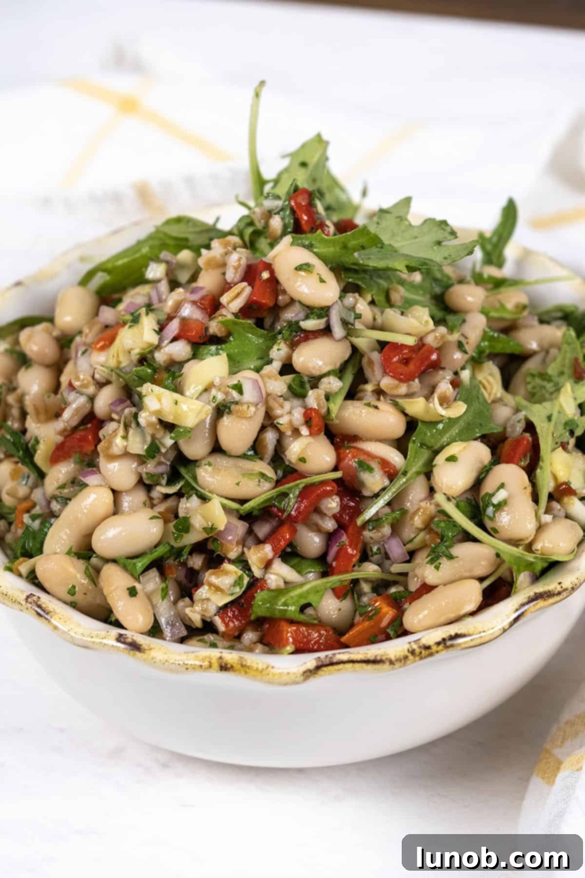 Mediterranean Farro White Bean Salad 8 A large ceramic bowl filled with colorful Italian Bean Salad, ready to be served.