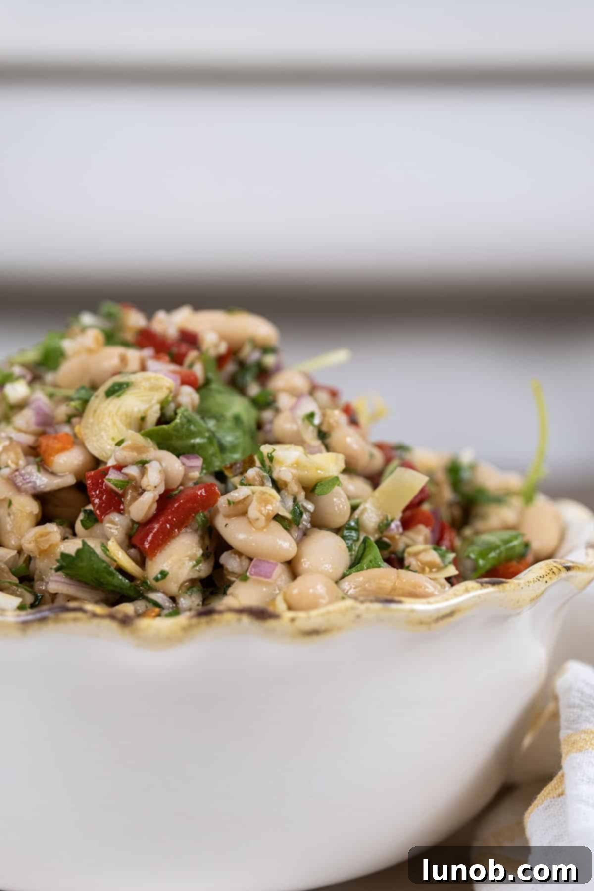 Mediterranean Farro White Bean Salad 9 A large serving bowl filled with the colorful and inviting Summer Farro Salad, garnished with fresh herbs.