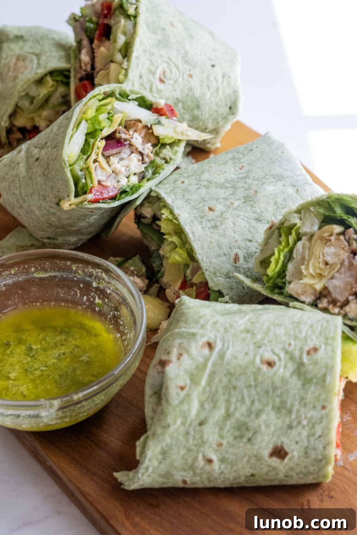 Zesty Mediterranean Chicken Pocket 11 A fresh Mediterranean chicken wrap, neatly rolled and presented on a serving platter.