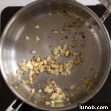 Mussels in Savory White Wine Broth 5 Minced garlic, crushed red pepper, and oregano joining the translucent shallots in the pan, releasing their aromas.