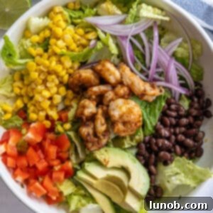 grilled shrimp salad with beans, red pepper, corn, red onion, beans, and avocado