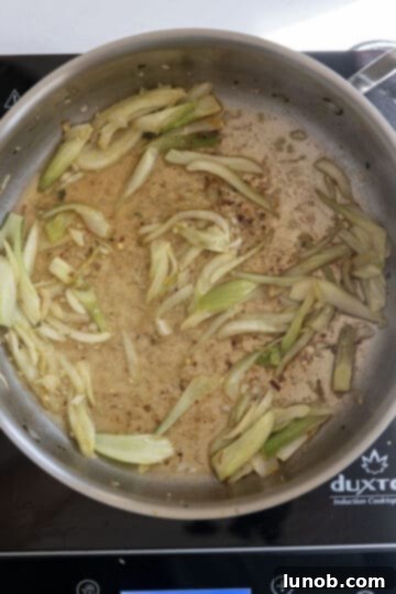 Rustic Sausage and Fennel Pasta 6 White wine being poured into the pan with sautéed fennel to deglaze.