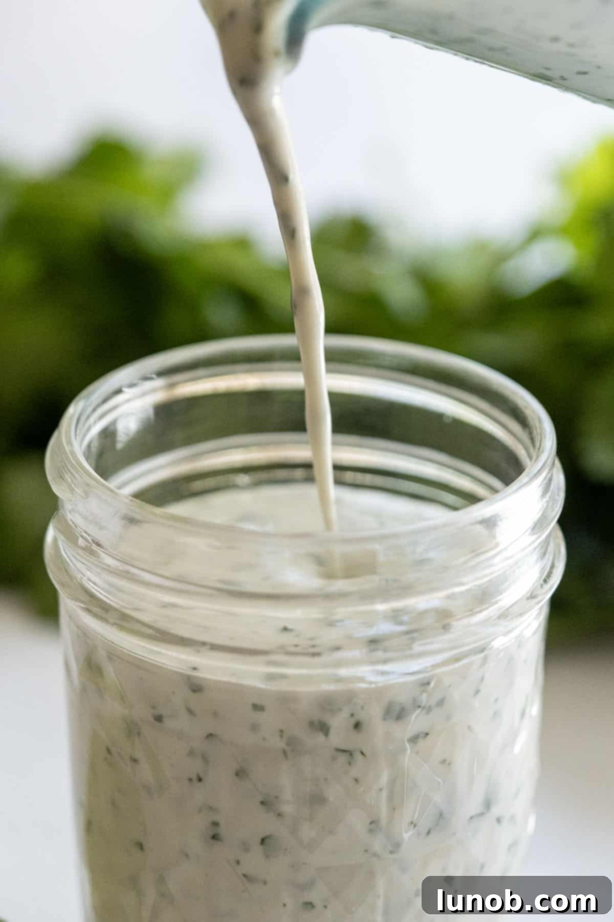 pouring cilantro lime ranch in a mason jar
