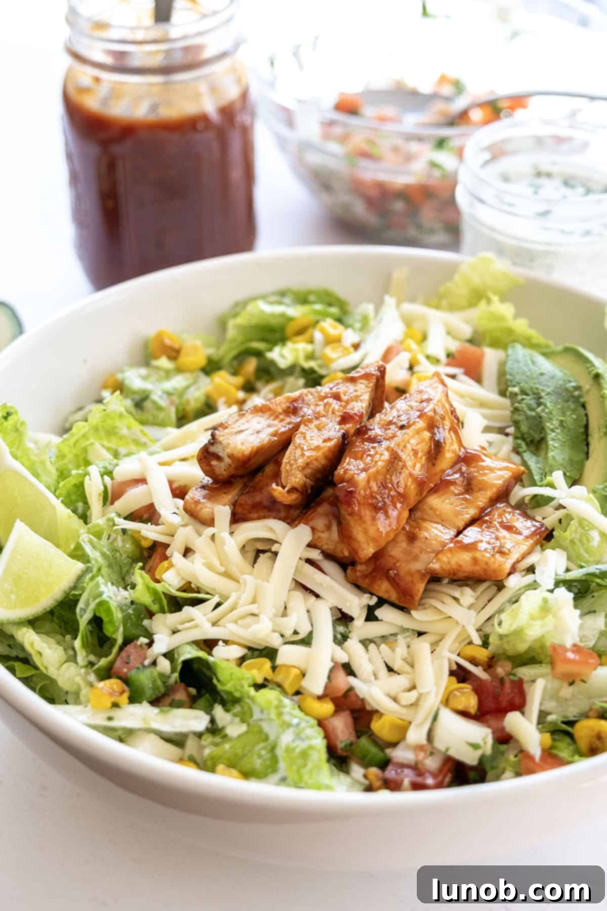 Zesty Chipotle BBQ Chicken Salad 8 Close-up of a finished Chipotle BBQ Chicken Salad showing all toppings beautifully arranged on a white plate, ready to be enjoyed.