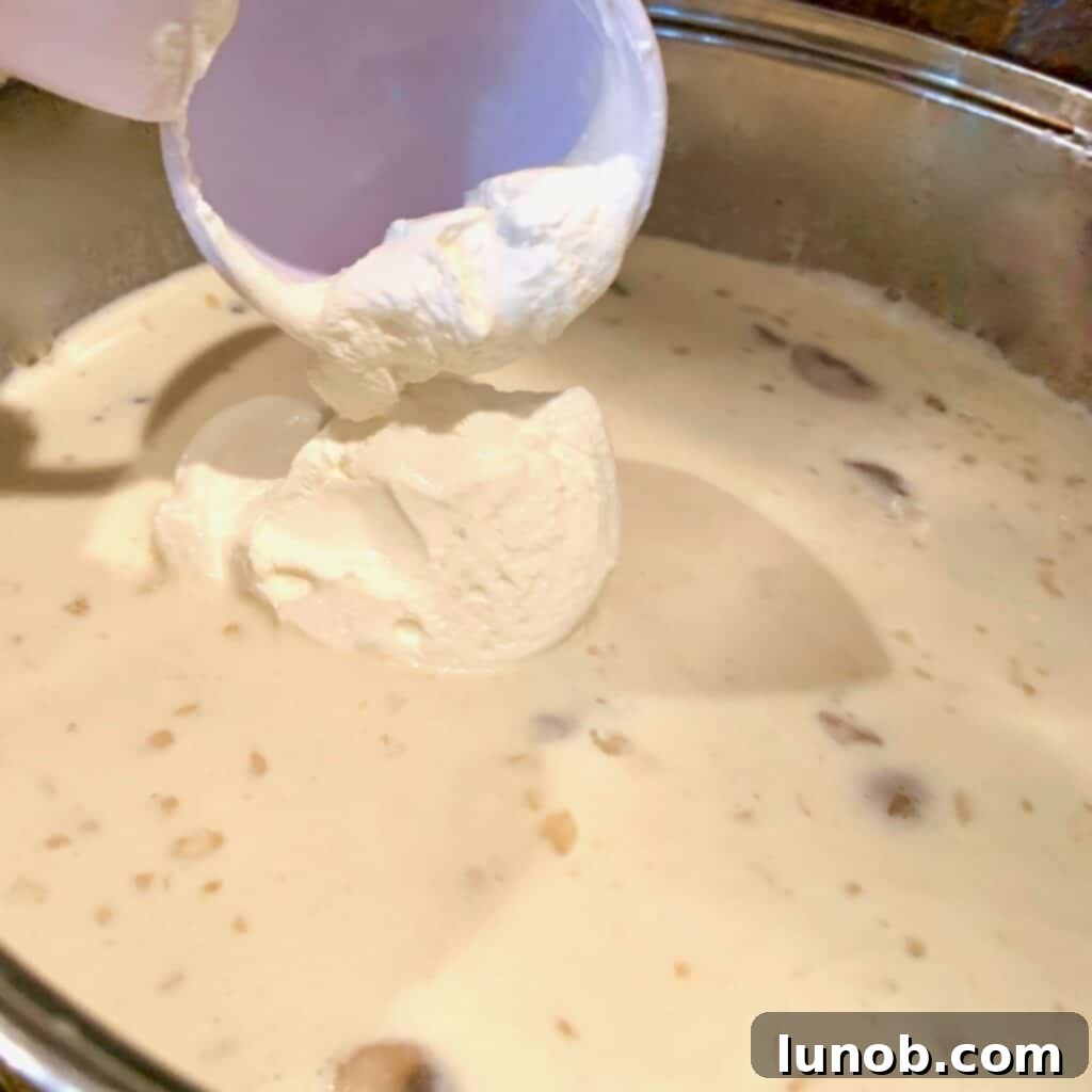 Turkey Tetrazzini: Cheesy Italian Delight with Crispy Garlic Butter Topping 12 Adding sour cream to the creamy Tetrazzini sauce