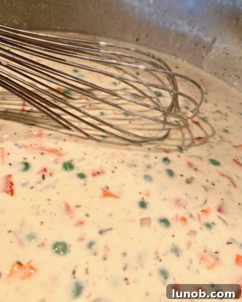 Turkey Tetrazzini: Cheesy Italian Delight with Crispy Garlic Butter Topping 17 Blending the Tetrazzini sauce with vegetables and spices