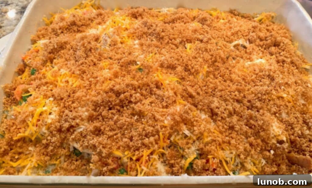 Turkey Tetrazzini: Cheesy Italian Delight with Crispy Garlic Butter Topping 25 Applying garlic buttercrumb topping over cheesy Turkey Tetrazzini