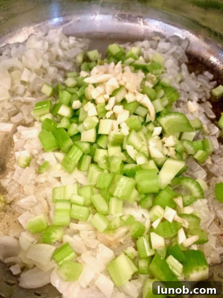 Turkey Tetrazzini: Cheesy Italian Delight with Crispy Garlic Butter Topping 4 Sautéing celery and minced garlic with onions for Tetrazzini