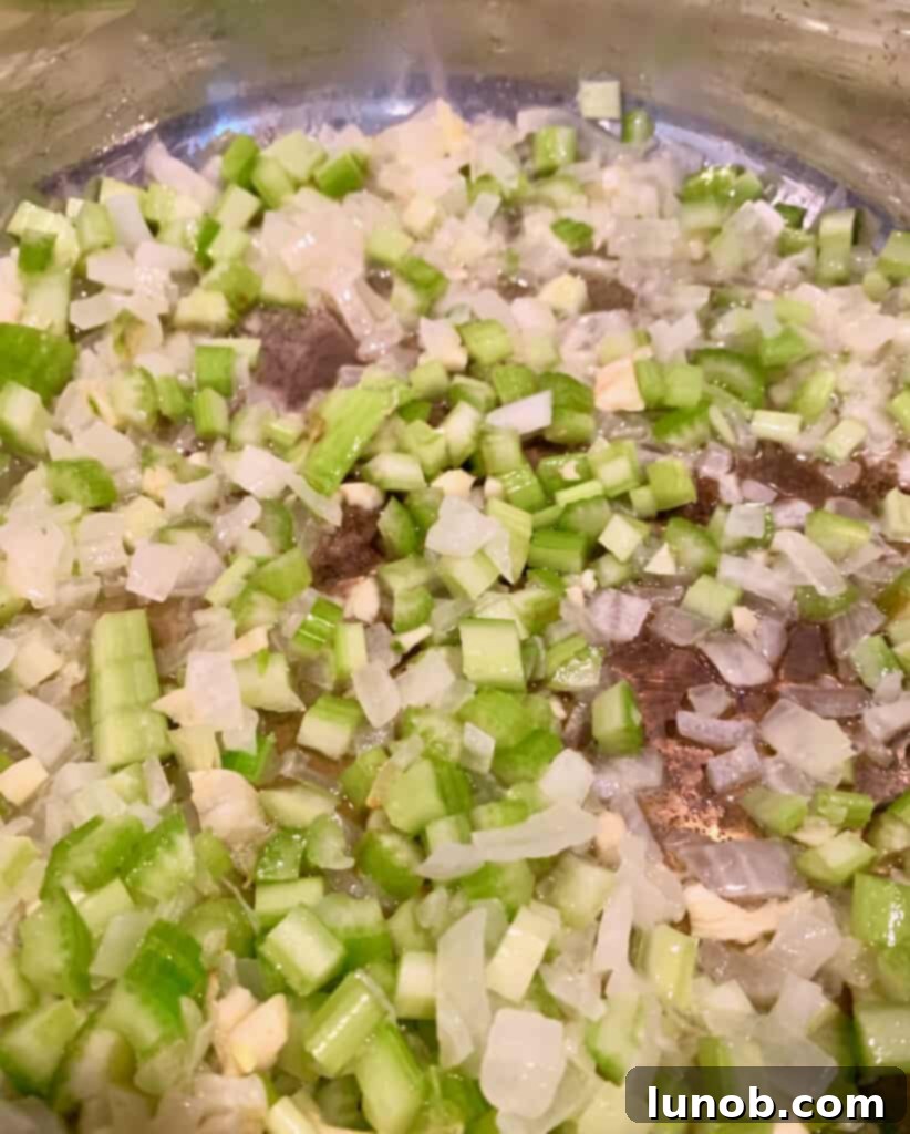 Turkey Tetrazzini: Cheesy Italian Delight with Crispy Garlic Butter Topping 5 Mixing sautéed onions, celery, and garlic in a pan for Turkey Tetrazzini