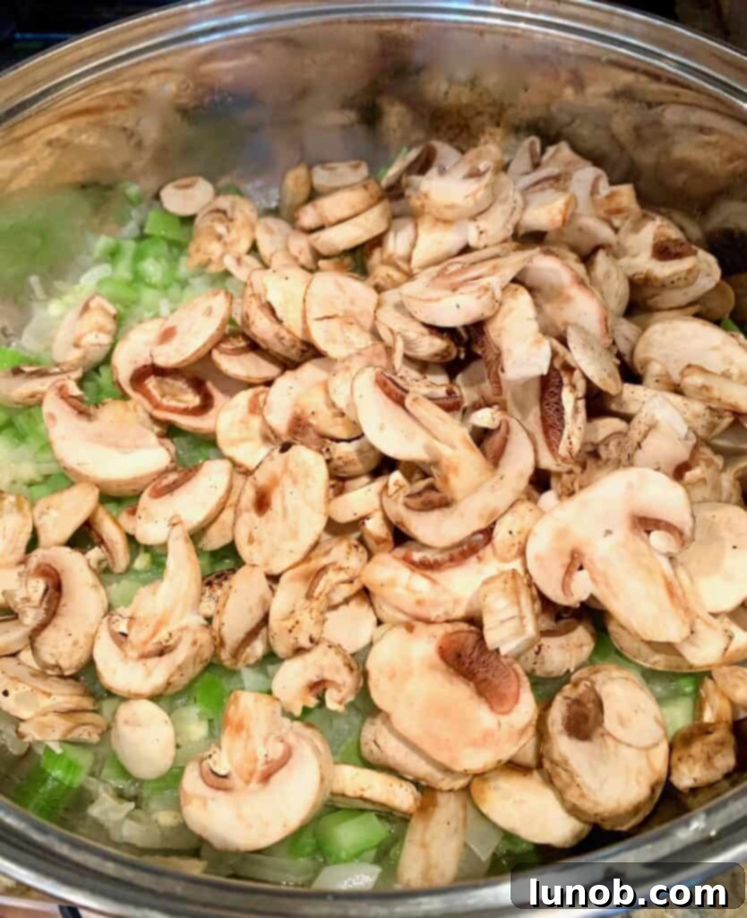 Turkey Tetrazzini: Cheesy Italian Delight with Crispy Garlic Butter Topping 7 Sautéing crimini mushrooms with vegetables for Turkey Tetrazzini