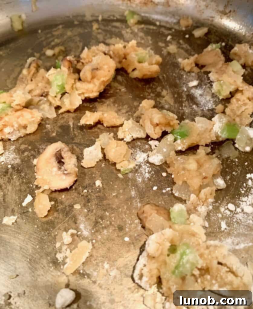 Turkey Tetrazzini: Cheesy Italian Delight with Crispy Garlic Butter Topping 9 Adding flour to the pan to create a roux for the Tetrazzini sauce