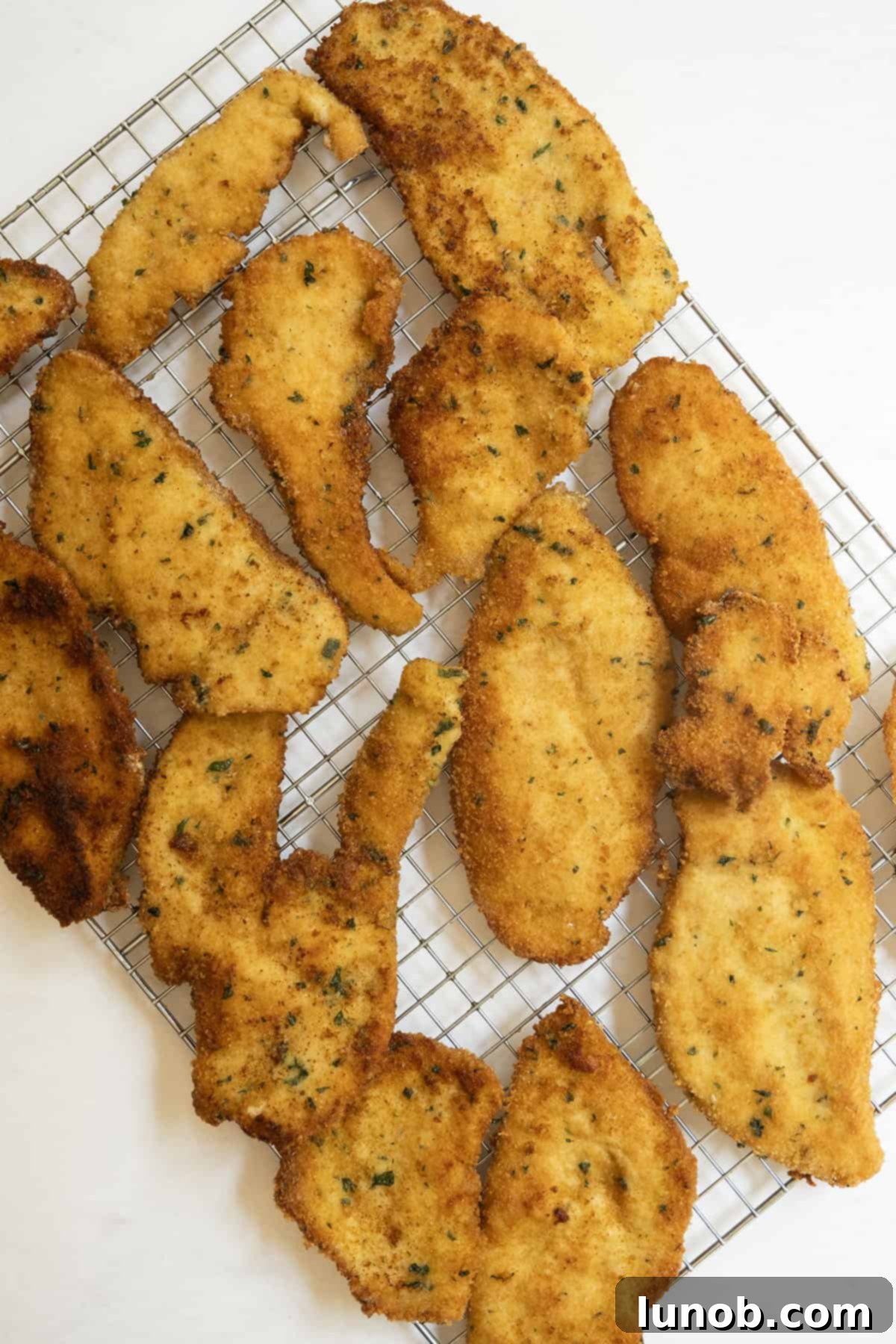 Crispy Italian chicken cutlets cooling on a wire rack.