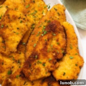 Crispy Italian chicken cutlets piled on a plate.