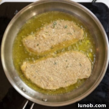Chicken cutlets frying in oil.