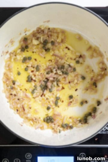 Capers and seasonings added to the sauteed red onion mixture