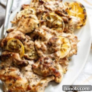 Zesty Grilled Lemon Pepper Chicken Thighs 9 Grilled lemon pepper chicken thighs on a wooden serving board