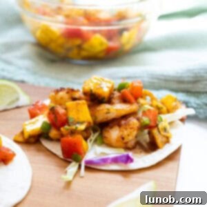 Shrimp Tacos with mango salsa, showcasing perfectly cooked shrimp and vibrant mango salsa on a taco.