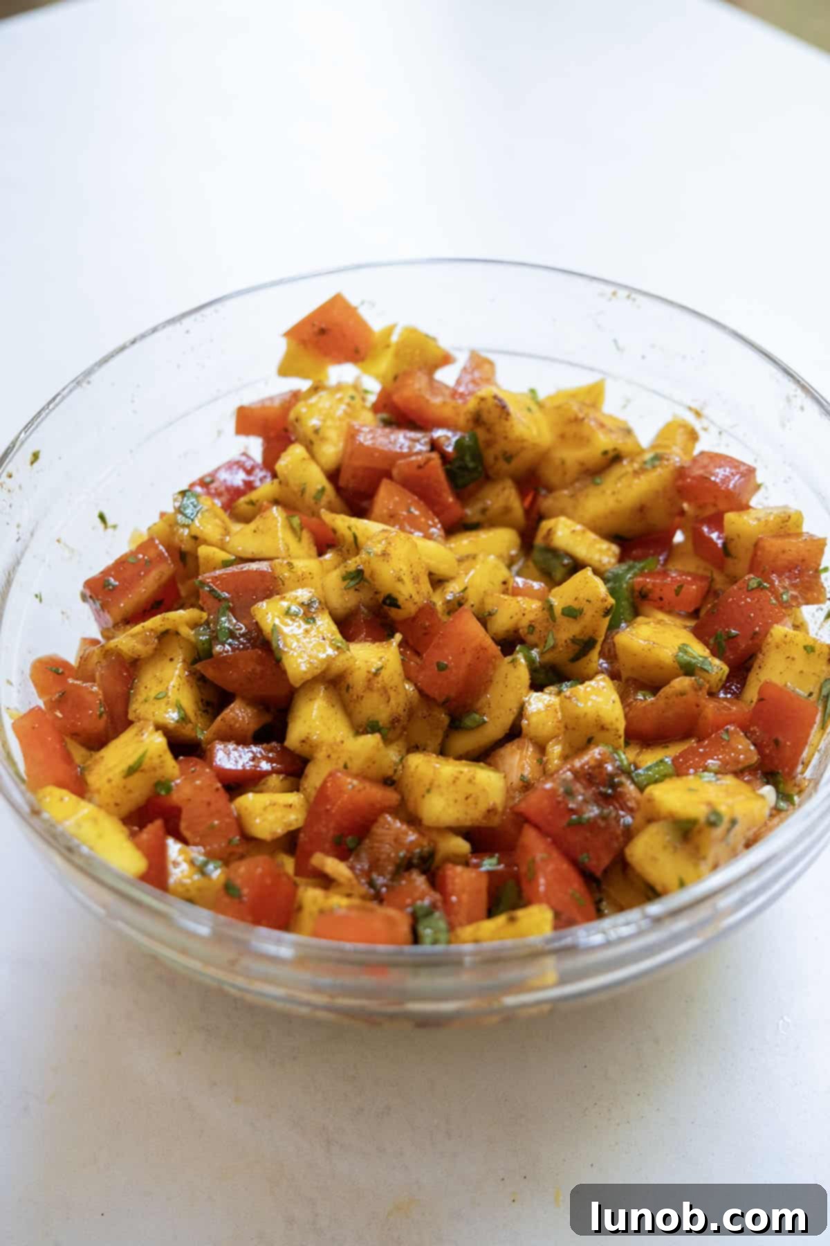 mango salsa in a bowl, featuring diced mango, red pepper, jalapeno, and cilantro, vibrant and ready to serve.