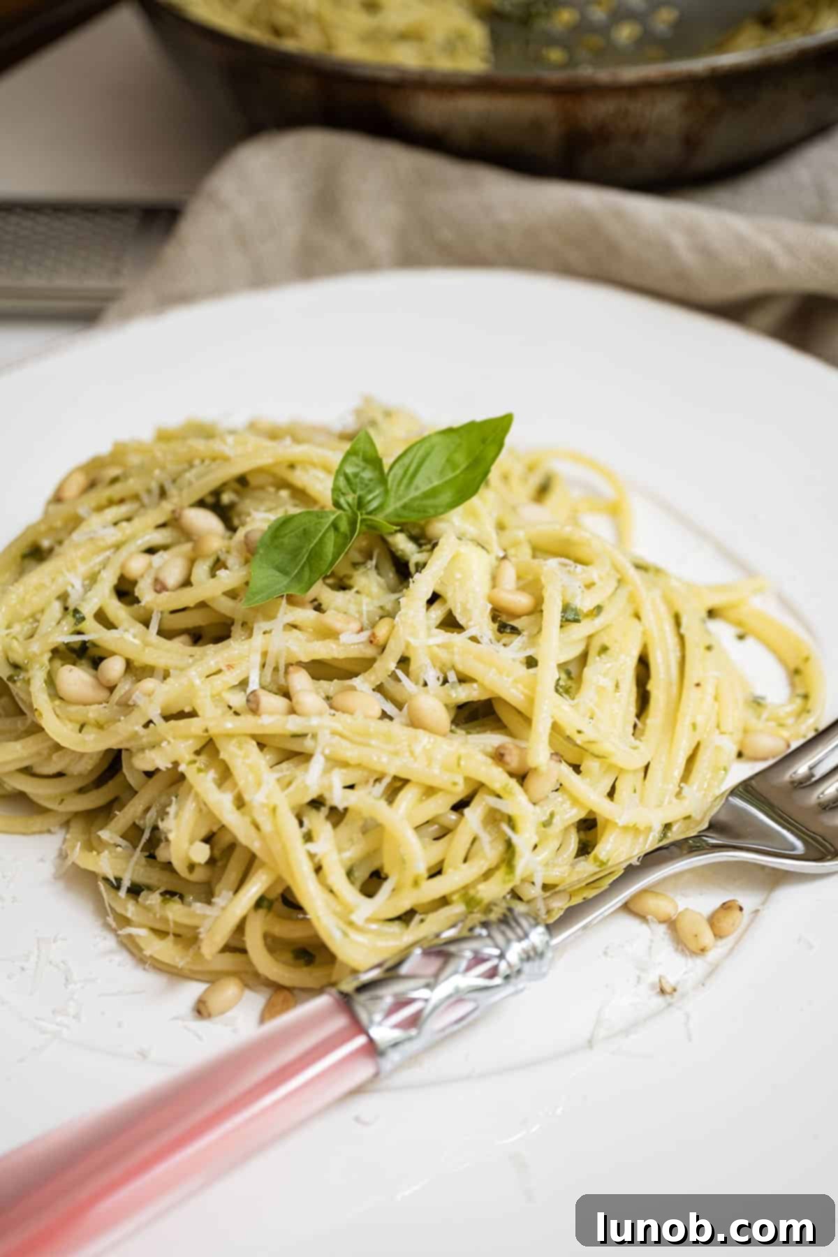 Mediterranean Artichoke Pesto Pasta 10 A beautifully plated bowl of Artichoke Pesto Pasta, garnished with pine nuts, fresh basil, and grated Parmesan, ready to eat.