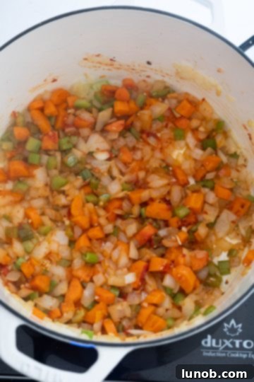 Hearty White Bean and Lentil Soup 6 Close-up of tomato paste slightly sticking to the bottom of the pot, indicating proper caramelization with the vegetables.