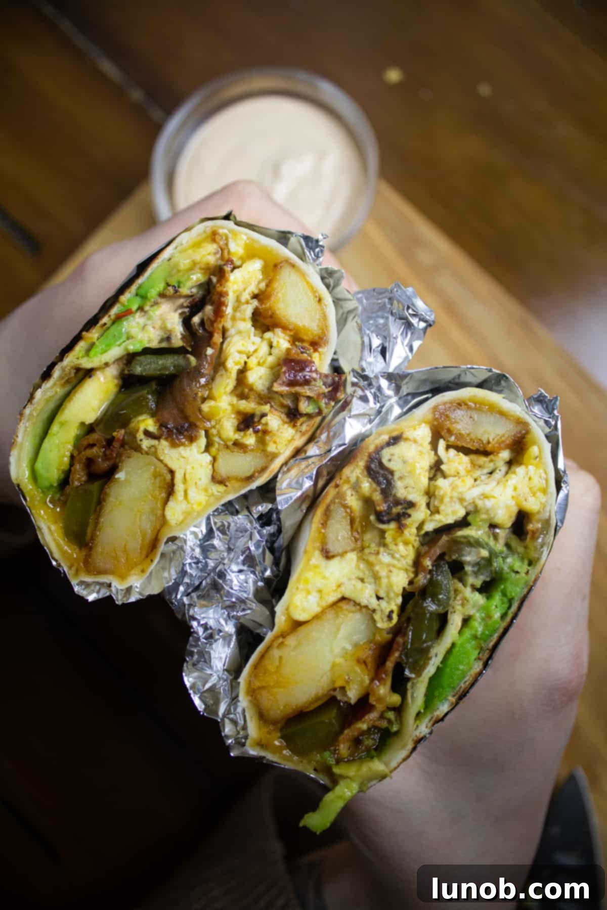 Zesty Southwest Potato Breakfast Burrito 2 A vibrant, loaded Southwest Potato Breakfast Burrito featuring peppers, potatoes, crispy bacon, fluffy eggs, and melted cheese, ready to be enjoyed.