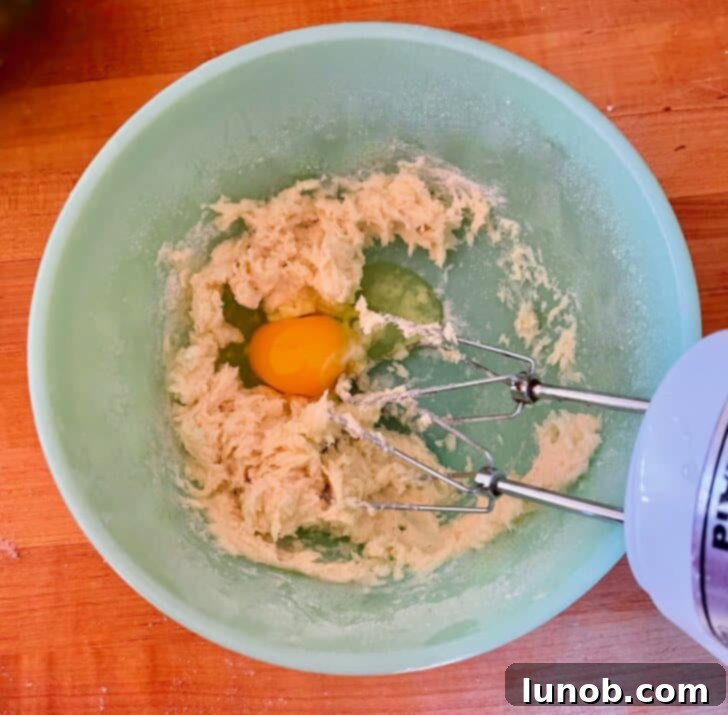 Limoncello Dokunuşlu Limonlu Ricotta Kurabiyeleri 7 Mixing eggs into the creamed butter and sugar mixture for cookie dough