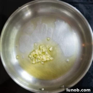 Smoky Grilled Stuffed Pork Chops 4 Minced garlic sauteing in the saucepan.