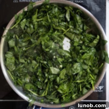 Smoky Grilled Stuffed Pork Chops 5 Spinach sauteing in the saucepan.