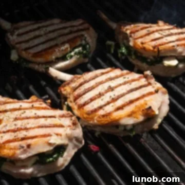 Smoky Grilled Stuffed Pork Chops 9 Seasoned pork chops on the grill flipped with grill marks.