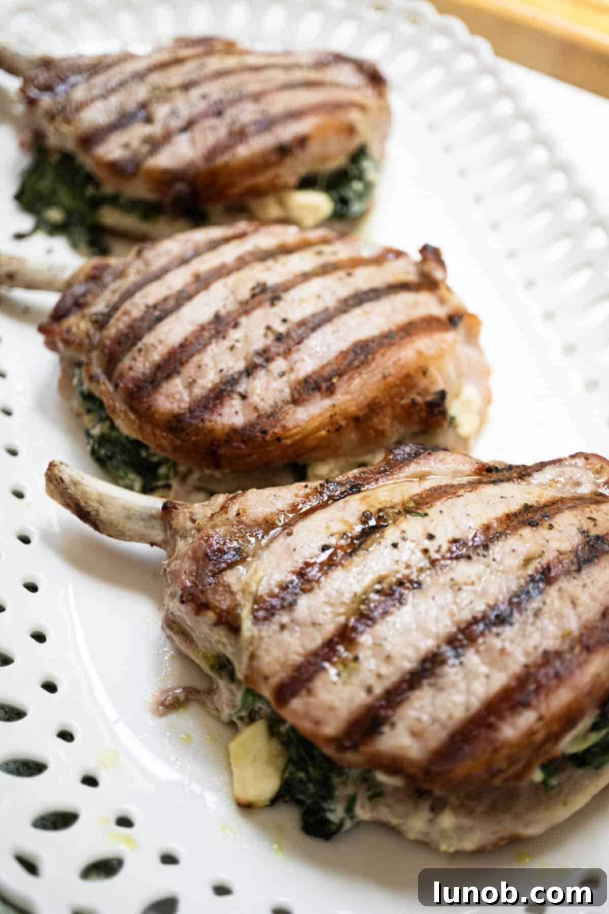 Smoky Grilled Stuffed Pork Chops 10 Grilled pork chop stuffed pork chops with feta and sauteed spinach and garlic.