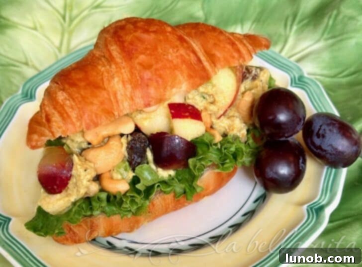 Close-up of Curry Chicken Salad showcasing vibrant red grapes and apple pieces.
