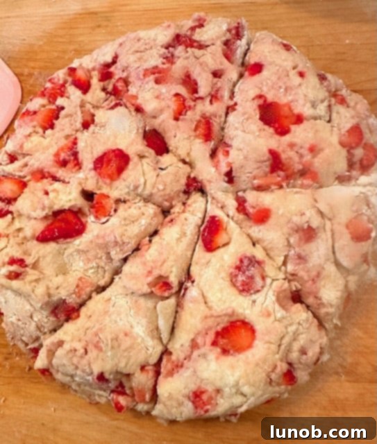 Scone triangles arranged on a parchment-lined baking sheet.