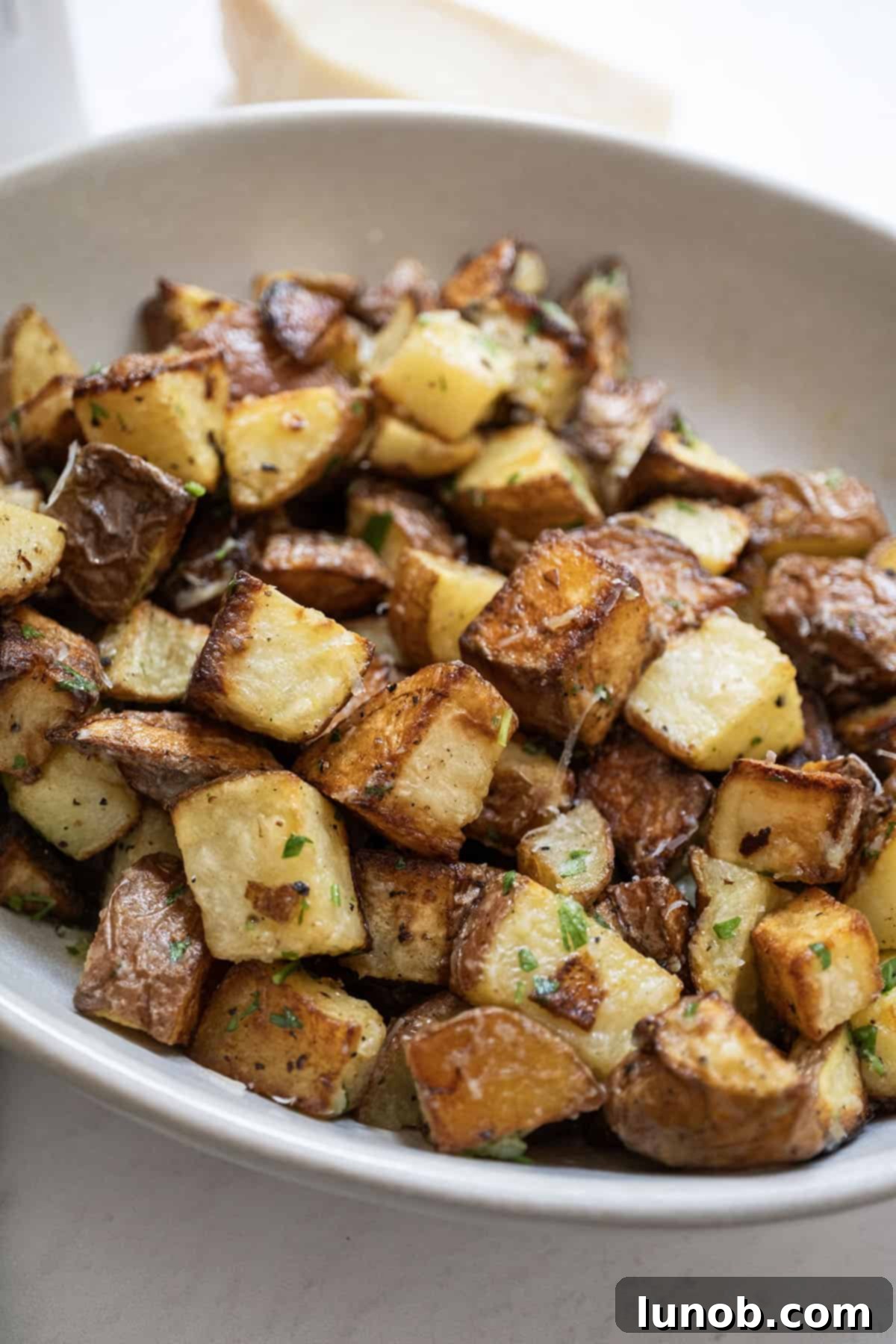 Ultimate Crispy Garlic Parmesan Potatoes 11 Crispy garlic parmesan potatoes served in a rustic bowl.