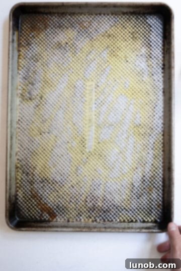 Ultimate Crispy Garlic Parmesan Potatoes 6 A baking tray with a generous layer of olive oil, ready for preheating.