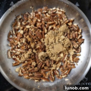 Combing pecans with brown sugar in a pan.