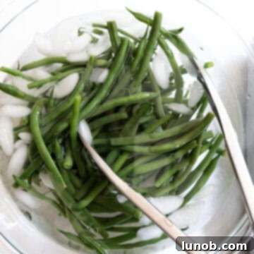 Garlic Parmesan Green Beans: A Timeless Classic 5 Green beans rapidly chilling in an ice water bath after blanching.