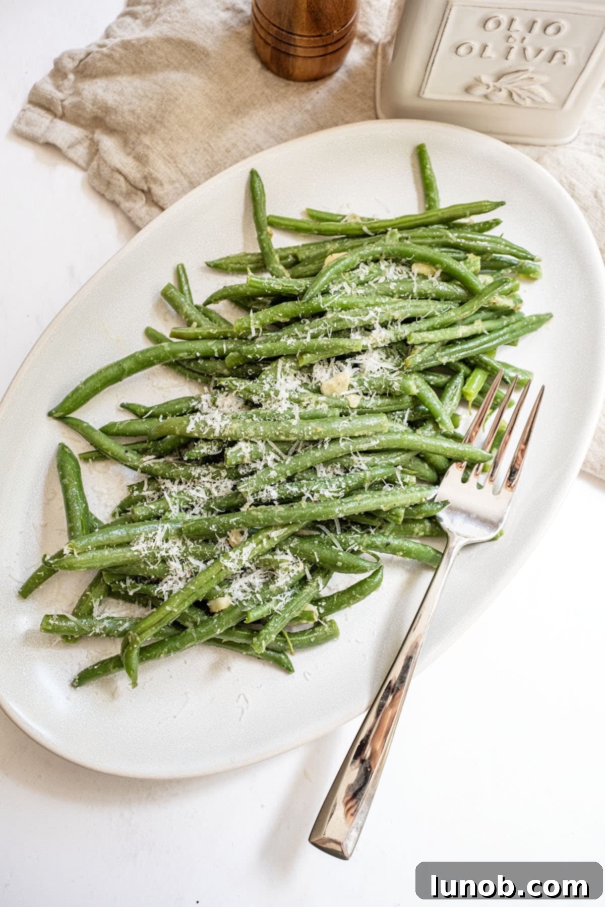 Garlic Parmesan Green Beans: A Timeless Classic 9 Sauteed green beans with garlic generously sprinkled with parmesan on a plate, ready to be served.