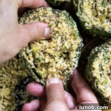 A bowl of seasoned breadcrumb mixture with cheese, garlic, and parsley.