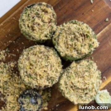 Artichokes stuffed with a cheesy breadcrumb mixture on a cutting board.