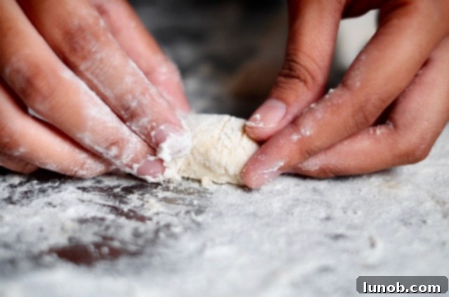 Cutting gnocchi dough ropes into small pieces.