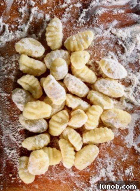 Shaping gnocchi on a gnocchi board to create ridges.